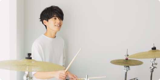 マンツーマンでドラムを教えてもらっている女性